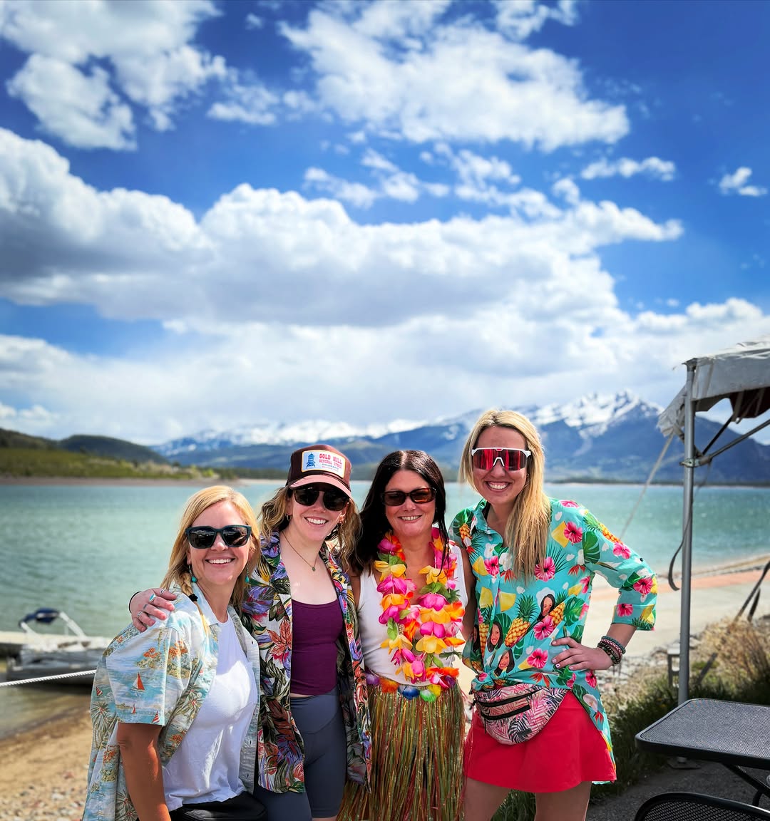 Friends in tiki shirts on the marina with the snowcapped Gore Range behind them.