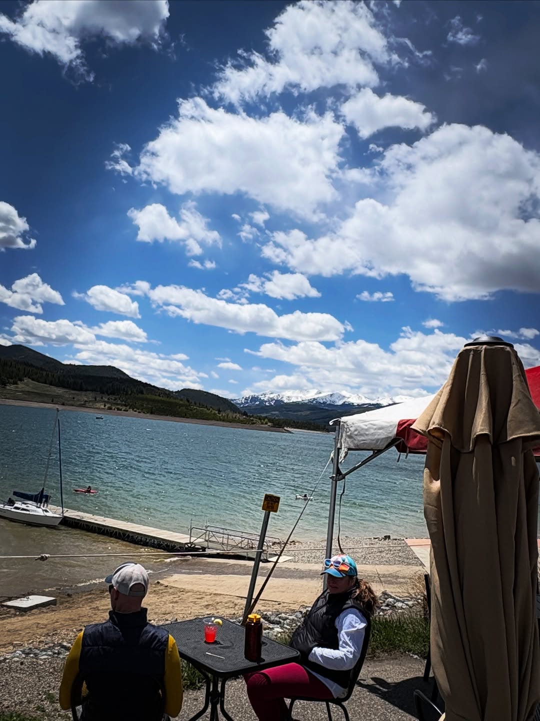 Dillon Reservoir from the deck — a sailboat on the shore, the Tenmile Range across the water.